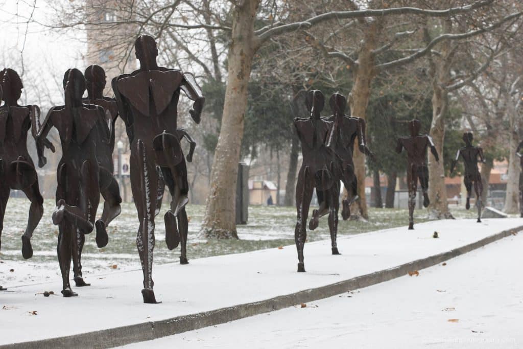 metal sculpture of people running